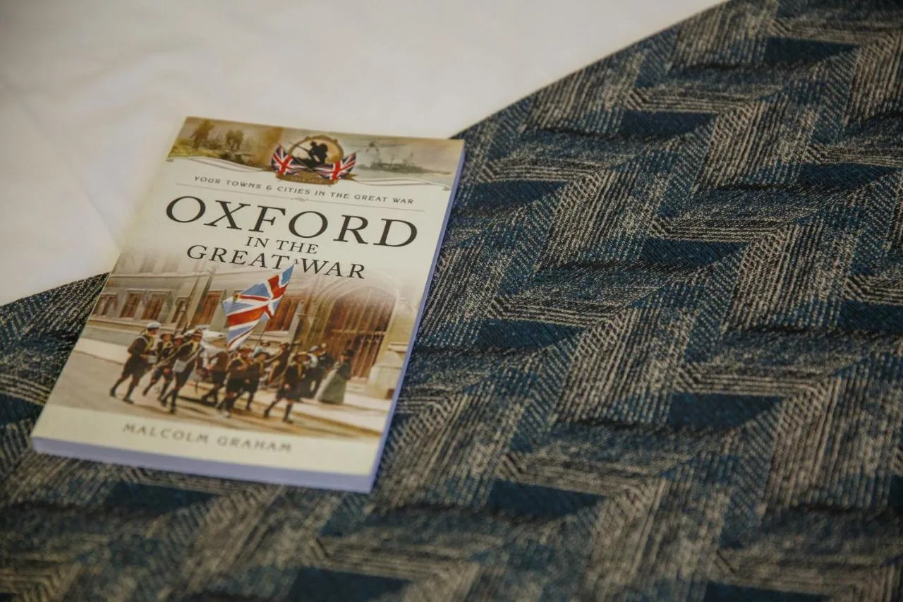 a book is sitting on top of a bed at The Buttery in Oxford